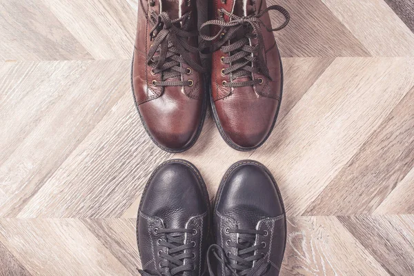 Чорно-коричневі кольори взуття на дерев'яному тлі. Концепція продажу та покупки. Копіювати простір. Прапор. Класична зимова тепла мода чоловічого взуття . — стокове фото