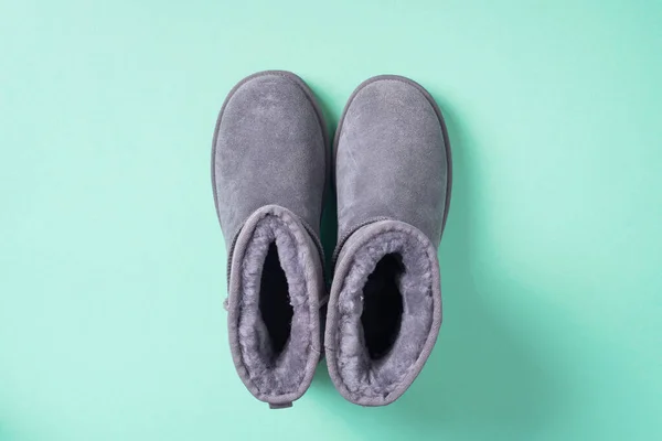 Grey ugg boots on blue background. Winter concept. Christmas and new year holiday. Copy space. — Stock Photo, Image