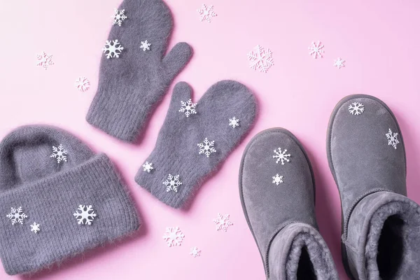 Winter warm clothes flat lay. Wool feminine clothes sweater, scarf, boots, snowflakes on pink background. Top view, copy space — Stock Photo, Image