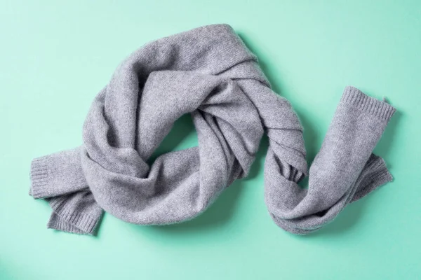 Grey knitted scarf on blue background. Top view, copy space. Winter warm clothes flat lay. Wool feminine clothes. Winter sale concept — Stock Photo, Image