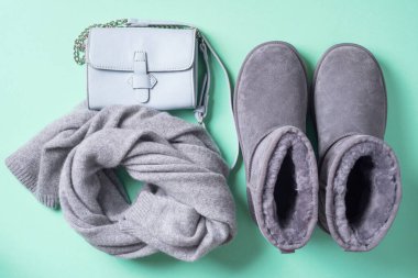 Moda konsepti yatıyordu. Kış sıcacık giysileri mavi arka planda yatıyordu. Yünlü kadın kıyafetleri, atkı, botlar, eko deri çanta. Üst görünüm, boşluğu kopyala. Pankart