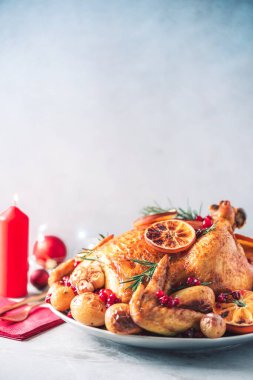 Kızarmış tavuk, şenlikli dekorasyon, mumlar, çimento arka planda hafif çukur. Geleneksel yeni yıl tatili ya da Noel kutlaması yemeği. Arkadaş ya da aile yemeği. Şenlikli Noel masası.