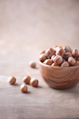 Ahşap kapta fındıklar, ahşap kaplama arka planda. Uzayı kopyala Süper yemek, vejetaryen, vejetaryen gıda konsepti. Fındık ezmesi, seçici odaklanma. Sağlıklı çerez.