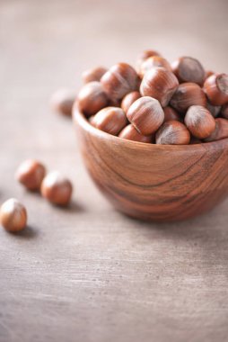 Ahşap kapta fındıklar, ahşap kaplama arka planda. Uzayı kopyala Süper yemek, vejetaryen, vejetaryen gıda konsepti. Fındık ezmesi, seçici odaklanma. Sağlıklı çerez.