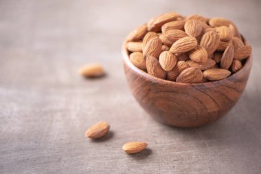 Tahta kapta badem fıstığı ve ahşap kaplama arka plan. Uzayı kopyala Süper yemek, vejetaryen, vejetaryen gıda konsepti. Badem fıstıklı makarnası, seçici odaklanma. Sağlıklı çerez