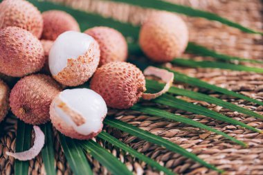 Arka planda palmiye yaprakları olan liçi meyveleri. Uzayı kopyala Egzotik litchi, lichee meyveleri. Tropikal gıda konsepti.