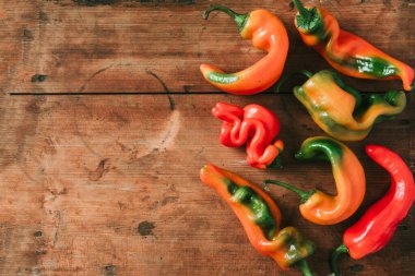 Ahşap arka planda çirkin dolmalık biber. Sıfır atık üretimi kavramı. Üst Manzara. Uzayı kopyala Gmo olmayan sebzeler