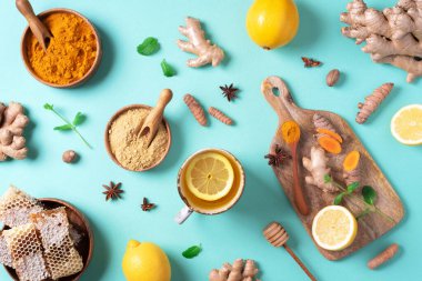 Mavi arka planda zerdeçal çayı için organik malzemeler. Antiviral içecek. Limon, zencefil, tarçın ve zerdeçal içeren sağlıklı ayurvedik içeceği. Bağışıklık güçlendirici ilaç