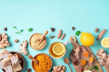 Limonlu, zencefilli ve mavi arkaplanlı baharatlı sağlıklı zerdeçal içeceği. Bağışıklık sistemi destekleyici gıda, antiviral içecek. Vejetaryen sıcak içecek konsepti.
