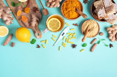 Sağlık, grip ve soğuk algınlığı tedavisi. Naturopati konsepti. Zencefil, limon, bal, haplar, ilaçlar, takviyeler, mavi arka planda termometre. Doğal alternatif bütünsel yaklaşım. Üst görünüm, alanı kopyala