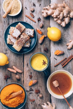 Zerdeçal latte için malzemeler. Zerdeçal tozu, sokağa çıkma yasağı kökü, tarçın, ahşap zemin üzerinde zencefil. Uzayı kopyala Antiviral içecek. Ayurvedik tedavi için baharatlar. Alternatif tıp konsepti.