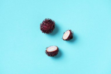 Mavi arka planda Rambutan meyveleri. Üst Manzara. Uzayı kopyala Tropik meyve. Nephelyum Lappaceum. Düz yatıyordu. Egzotik yiyecekler, tropikal meyve kavramı.