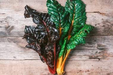 Ahşap arka planda çok renkli İsviçre pazarı. Üst Manzara. Uzayı kopyala Sıfır atık, organik sebzeler. Vejetaryen ve vejetaryen diyet yemekleri.