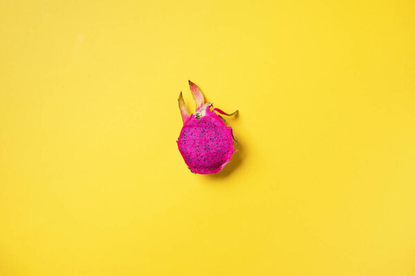 Pink pitahaya or dragon fruit on yellow background. Top view. Copy space. Creative design banner. Summer time. Tropical travel, exotic fruit. Vegan and vegetarian concept