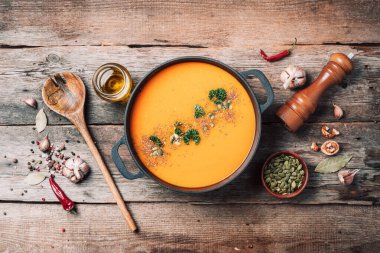 Balkabağı çorbası ahşap arka planda demir tencerede. Üst Manzara. Boşluğu kopyala.