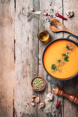 Balkabağı çorbası ahşap arka planda demir tencerede. Üst Manzara. Boşluğu kopyala.