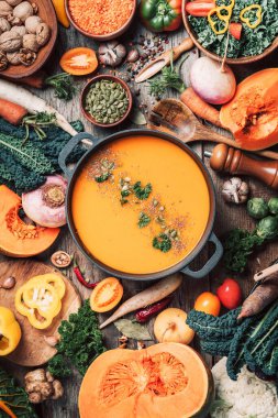 Vejetaryen yemek malzemeli balkabağı çorbası, tahta kaşıklar, ahşap arka planda mutfak aletleri. Üst Manzara. Vejetaryen diyeti. Sonbahar hasadı. Sağlıklı, temiz yemek ve yeme konsepti. Sıfır atık