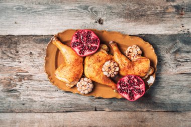 Geleneksel Şükran Günü kutlama partisi. Ahşap zemin üzerinde nar ve sarımsaklı kızarmış tavuk. Arkadaş ya da aile yemeği. Şenlikli Noel masası. Üst görünüm