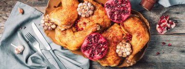 Geleneksel Şükran Günü kutlama partisi. Ahşap zemin üzerinde nar ve sarımsaklı kızarmış tavuk. Arkadaş ya da aile yemeği. Şenlikli Noel masası. Üst görünüm