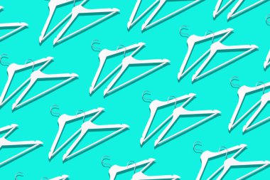 Beyaz elbise askılarının üst görüntüsü mavi arkaplanda ve fotokopi alanı var. Düz yatıyordu. Minimalizm tarzı ve azalma. Yaratıcı düzen. Moda, mağaza satışı, alışveriş konsepti. Kadınsı blog için afiş.