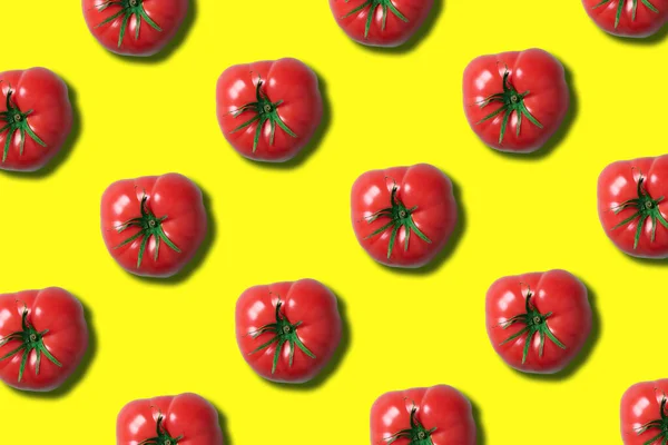 Red tomato pattern on trendy yellow background with copy space. Top view. Flat lay. Creative packing design. Summer minimal concept. Vegan and vegetarian diet.