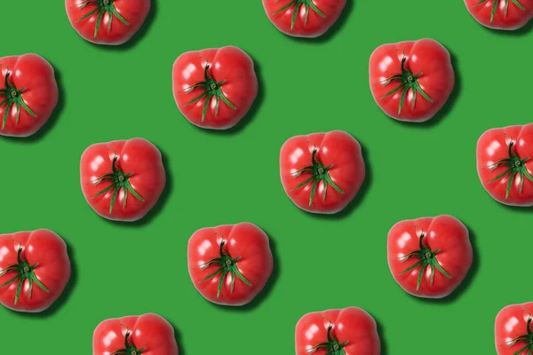 Red tomato pattern on trendy green background with copy space. Top view. Flat lay. Creative packing design. Summer minimal concept. Vegan and vegetarian diet.