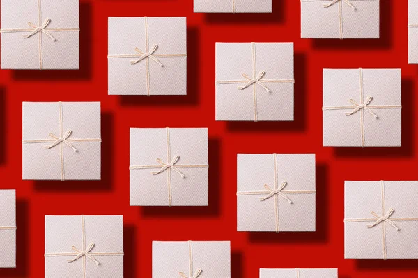 Día de San Valentín. Patrón de caja de regalo gris sobre fondo rojo. Vista superior. Copiar espacio. Diseño creativo para el embalaje. Fondo festivo para vacaciones: Cumpleaños, San Valentín, Navidad, Año Nuevo . — Foto de Stock