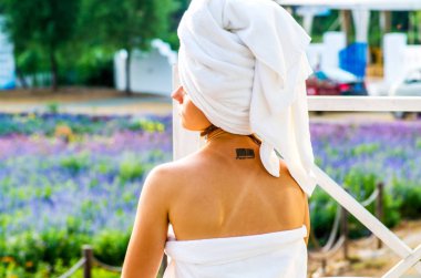 bir kadınla bir dövme banyo havlusu içinde bir salon üzerinde oturuyor