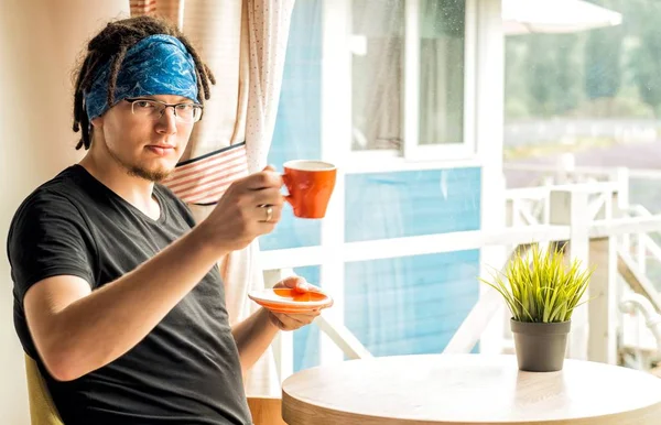 Ein Mann mit Dreadlocks trinkt zu Hause Kaffee — Stockfoto