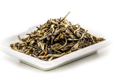 yeşil çay yaprakları beyaz dikdörtgen plaka üzerinde