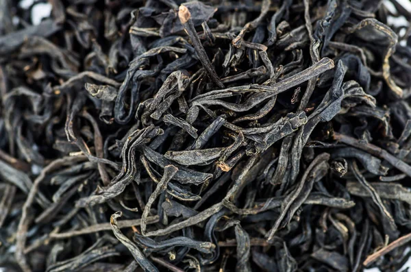 Разброс листьев черного чая на белом фоне — стоковое фото