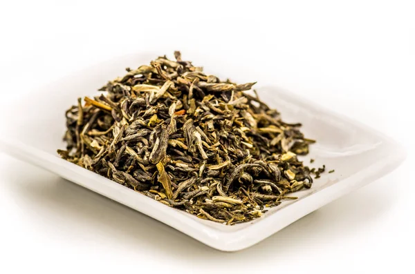 Зеленый чай листья на белой прямоугольной пластине — стоковое фото