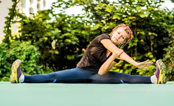 dreadlocks ile atletik kadın bir parkta spor egzersizleri yapıyor