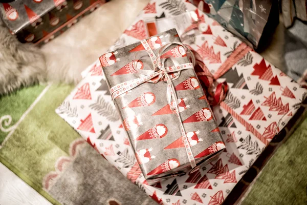 Vánoční dárky na koberečku u vánočního stromu — Stock fotografie