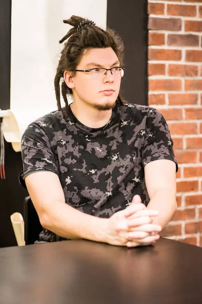 Young caucasian hipster business man sitting on the table — Stock Photo, Image