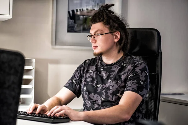 Młody mężczyzna kaukaski, pracujący w biurze przy komputerze — Zdjęcie stockowe