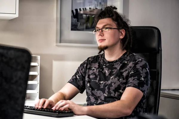 Młody mężczyzna kaukaski, pracujący w biurze przy komputerze — Zdjęcie stockowe