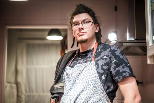 Joven en delantal en la cocina — Foto de Stock