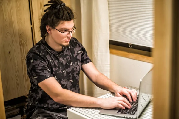 Młody człowiek z dredami pracy na laptopie — Zdjęcie stockowe