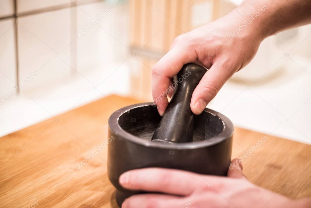 hands using mortar and pestle