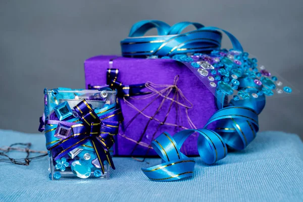 Vánoční řemesla složení na modrý ubrus. svíčka s drahokamy a modrou stužkou, dárky a vánoční ozdoby — Stock fotografie