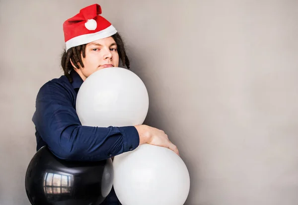 Feliz yong hombre con globos en santa hat — Foto de Stock