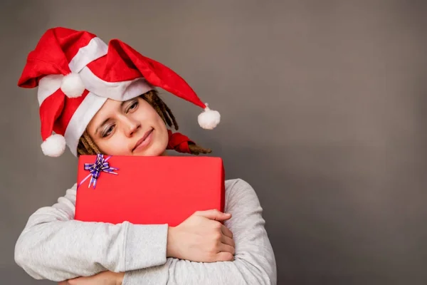 Navidad mujer feliz abrazando un bonito regalo rojo — Foto de Stock