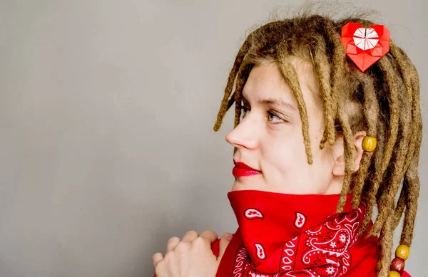 Unga kaukasiska hipster kvinna med dreadlocks och en origami hjärta i håret ser fram — Stockfoto