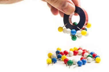 metal pim çeken bir mıknatıs tutan adam el