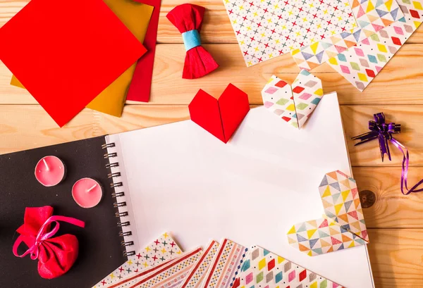Ручной работы оригами бумажные сердца на день Святого Валентина в окружении бумаги оригами — стоковое фото