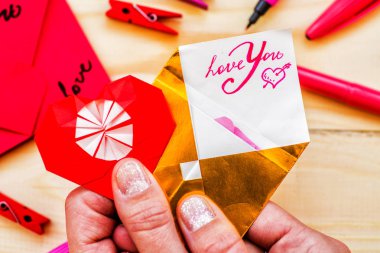 Sevgililer günü tatil. kadın eli bir origami kalp ve zarf ile