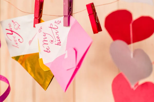 valentine's day concept. origami paper envelopes crafts hanging on wooden background