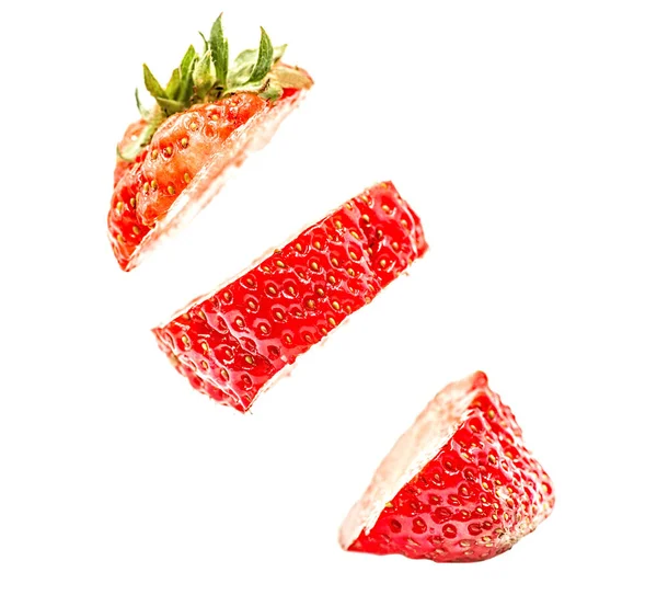 Aufgeschnittene Erdbeere, die isoliert auf weißem Hintergrund in der Luft schwebt. Erdbeere in Stücken in der Luft. — Stockfoto