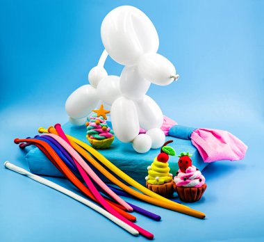 parti öğeleri. parti el sanatları. Balon köpek, kil cupcakes, hediye ve balon parlak mavi zemin üzerine bir yayla